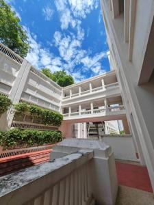 a large white building with a walkway in front of it at Sweet Cozy Marina Suite at Straits Quay in Tanjong Tokong