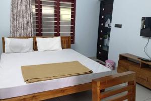 a bedroom with a bed with a yellow blanket on it at Bk farmhouse homestay in Bālarāmpuram