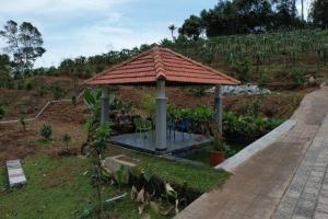 a small gazebo with a roof on a field at Bk farmhouse homestay in Bālarāmpuram +2 photos