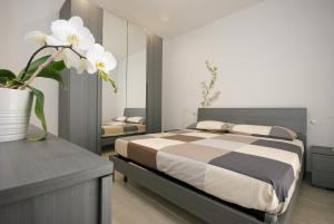 a bedroom with a bed and a vase with flowers at Residenza Adua Evangelisti Casa in Bellaria-Igea Marina