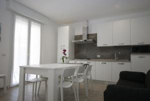 a white kitchen with a white table and chairs at Residenza Adua Evangelisti Casa in Bellaria-Igea Marina