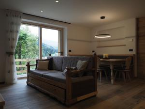 a living room with a couch and a table at Cabassa Moena by Go new location in Moena