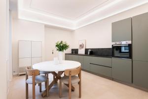 a kitchen with a white table and chairs and a counter at RELSTAY - Montenapoleone in Milan