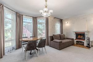 a living room with a table and a couch and a fireplace at Bukovel Hotel in Bukovel
