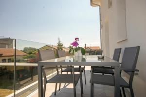 a dining room table with chairs and a vase with flowers at Residenza Adua Evangelisti Casa in Bellaria-Igea Marina