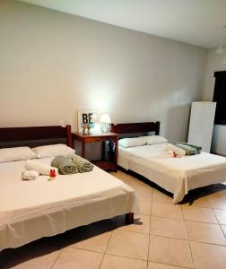 a room with two beds and a table at Mansão Sunset Beach House in São Sebastião