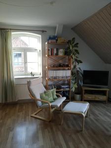 a living room with a chair and a television at Ferienwohnung Seeblick in Plau am See