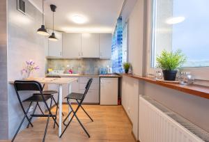 kuchnia ze stołem i krzesłami w pokoju w obiekcie Apartament Centrum 32m2 Kłodzko - Przyjaciół Ziemi Kłodzkiej - Spokój, Cisza, Bliskość Atrakcji w Kłodzku