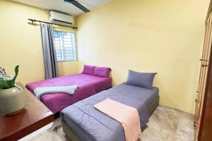 two beds sitting next to each other in a room at Bercham 81 Homestay in Ipoh