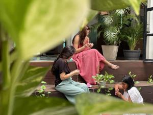 drei Frauen sitzen auf den Stufen eines Hauses in der Unterkunft MuchoSur Santa Marta in Santa Marta