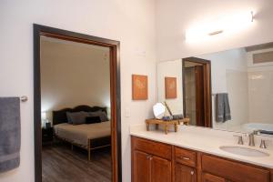 une salle de bain avec un lavabo, un miroir et un lit dans l'établissement City Council Chambers, à Rochester 28 autres photos