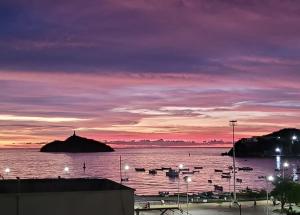 einen Sonnenuntergang über einem Wasserkörper mit Booten darin in der Unterkunft MuchoSur Santa Marta in Santa Marta