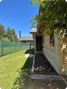a brick house with a door and a yard at Cabaña de Luxe en la Estepa in San Carlos de Bariloche +18 photos
