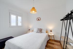 a white bedroom with a bed and a window at Casa do Lago in Campinho +13 photos