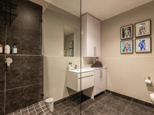 a bathroom with a shower and a sink at 105 Queens Park in Cape Town