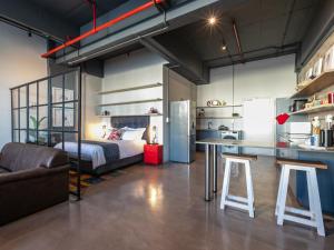 a loft bedroom with a bed and a table and stool at 105 Queens Park in Cape Town +21 photos