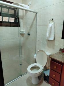 a bathroom with a toilet and a glass shower at Mansão Sunset Beach House in São Sebastião +16 photos