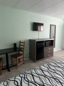 a room with a desk and a television and a chair at Royal Canadian Motel in Wildwood
