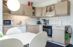 a kitchen with wooden cabinets and white appliances at 3 Bedroom Gorgeous Home In Allinge in Allinge