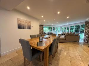 a dining room with a wooden table and chairs at Trewhiddle Retreat V17 by Together Travel - Luxury 4-Bedroom Villa in St Austell
