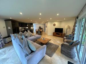 a living room with a couch and a table at Trewhiddle Retreat V17 by Together Travel - Luxury 4-Bedroom Villa in St Austell