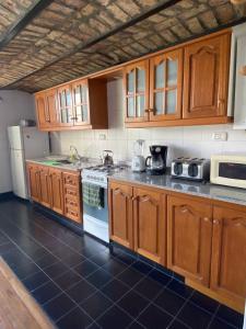 Una cocina con gabinetes de madera y un refrigerador blanco. en Rincón Histórico San Telmo, en Buenos Aires