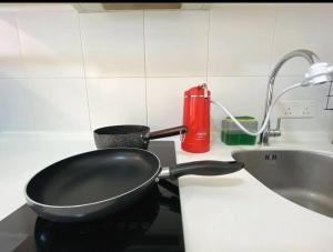 a frying pan sitting on a counter next to a sink at Petaling Jaya 1-12pax Muji design 3 room 1 min to Sunway Giza in Petaling Jaya