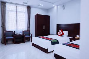 a hotel room with two beds and a table and chairs at Khách sạn 88 mộc châu in Mộc Châu