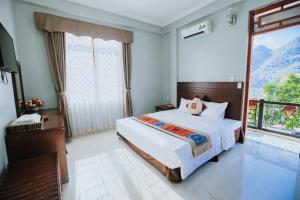 a bedroom with a large bed and a balcony at Khách sạn 88 mộc châu in Mộc Châu