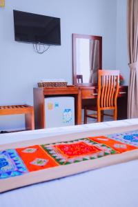 a bedroom with a bed and a table and a desk at Khách sạn 88 mộc châu in Mộc Châu