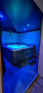 a jacuzzi tub in a room with blue lights at Le Clos Maldier - Gîte de la Belle vue in Laon