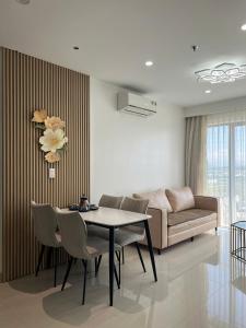 a living room with a table and chairs and a couch at Tom homestay, căn hộ Nera garden Huế in Hue