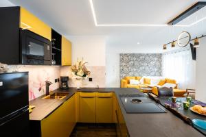 a kitchen with yellow cabinets and a living room at Enchantress'Apartment Designed By CM in Sélestat