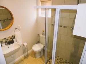 a bathroom with a toilet and a sink and a shower at Sea-Mazing at The Dunes in Plettenberg Bay +7 photos