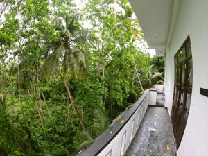 a balcony of a house with trees and plants at Wijaya Villa in Habaraduwa