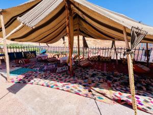 a large tent with a rug on the ground at Hôtel familiale les grotte in Aït Benhaddou