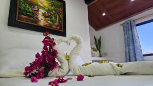a bedroom with a bed with a swan made out of flowers at Flor's House in San Cristobal