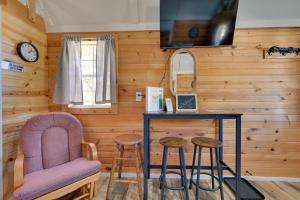 una habitación con una silla, una mesa y taburetes en Cabin on Rivers Edge Trail in Steamboat Rock!, en Steamboat Rock