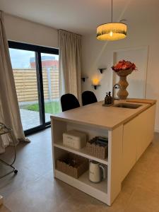 a kitchen with a island with a sink and a counter at Maison Olive in Torhout