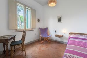 una camera da letto con un letto, due sedie e una finestra di Poggetti San Luigi Country Home Follonica a Follonica