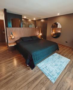 Un dormitorio con una cama grande y un espejo. en Dharma Hotel Boutique Spa, en San Jerónimo