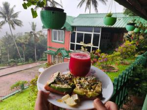 a person holding a plate of food with a drink at Nestinggrounds in Mudigere