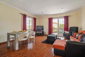 a living room with a table and a couch at Palm Tree House by Homie in Ponta Delgada