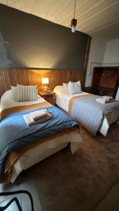 two beds in a hotel room with at Hospedaje "Room" in El Chalten