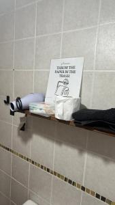 a shelf in a bathroom with a sign on it at Hospedaje "Room" in El Chalten
