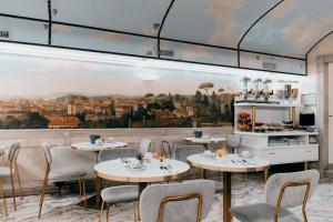a restaurant with tables and chairs and a painting on the wall at Hotel Pantheon in Rome