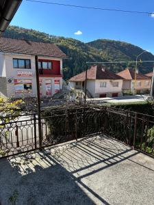 a gate in front of a building with mountains in the background at Kuća marinković in Vlasenica +2 photos