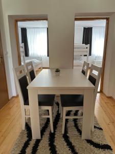 a white dining table and chairs in a room at Kuća marinković in Vlasenica