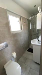 a bathroom with a toilet and a sink and a window at Domki Kajuta 3 in Żarnowska +14 photos