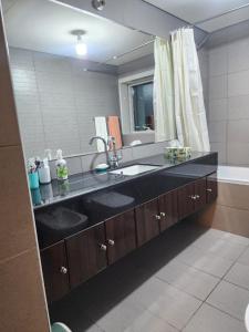 a bathroom with a sink and a large mirror at Delmon دلمون in Abu Dhabi